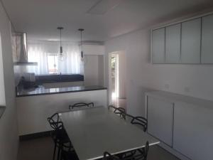 een witte keuken met een tafel en stoelen. bij Sobrado com piscina e campinho! in Boa Vista