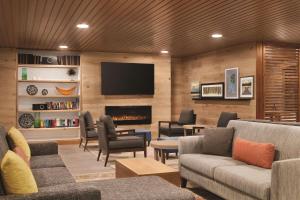 sala de estar con sofá y chimenea en Country Inn & Suites by Radisson, Sevierville Kodak, TN, en Kodak