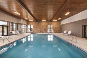 una piscina con sillas y mesas en un edificio en Country Inn & Suites by Radisson, Sevierville Kodak, TN, en Kodak