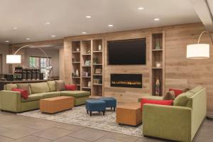 a living room with a fireplace and a tv at Country Inn & Suites by Radisson, Nashville Airport East, TN in Nashville