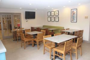 a restaurant with tables and chairs and a television at Country Inn & Suites by Radisson, Nashville, TN in Nashville