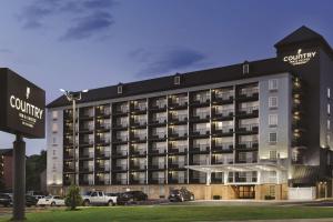 a hotel building with cars parked in a parking lot at Country Inn & Suites by Radisson, Pigeon Forge South, TN in Pigeon Forge