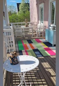 una terrazza con tavolo, sedie e tappeto colorato di Wanha Neuvola Guesthouse & Apartment a Pieksamaki