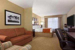 Habitación de hotel con sofá y cama en Country Inn & Suites by Radisson, Knoxville at Cedar Bluff, TN, en Knoxville