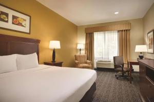 a hotel room with a bed and a desk and a window at Country Inn & Suites by Radisson, Goodlettsville, TN in Goodlettsville