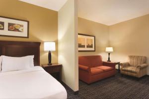 um quarto de hotel com uma cama e uma cadeira em Country Inn & Suites by Radisson, Goodlettsville, TN em Goodlettsville