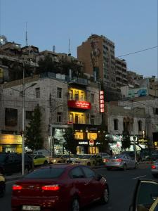 una concurrida calle de la ciudad con coches y edificios en Roman Theater Hotel, en Amán