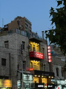 ein Gebäude mit Neonschildern an der Seite in der Unterkunft Roman Theater Hotel in Amman