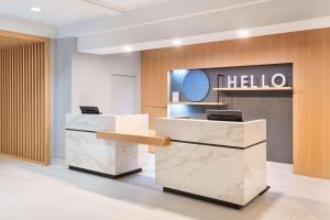 a hotel lobby with a reception desk and a clock at Radisson Hotel Nashville Airport in Nashville