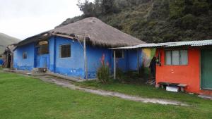 una casa azul y roja con techo de hierba en Hacienda Yanahurco, en Ovejería 28 fotos más