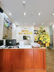 an office with a desk with a computer and flowers at Sky Star 2 Hotel in Can Tho
