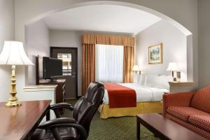 a hotel room with a bed and a desk and chair at Country Inn & Suites by Radisson, Fort Worth West l-30 NAS JRB in Fort Worth