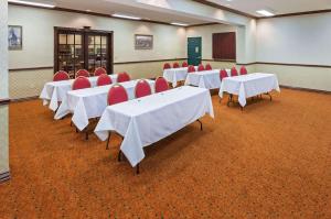 a conference room with white tables and red chairs at Country Inn & Suites by Radisson, Amarillo I-40 West, TX in Amarillo
