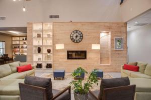 sala de estar con reloj en la pared en Country Inn & Suites by Radisson, Harlingen, TX, en Harlingen