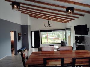 a living room with a wooden table and a dining room at Casa Ton Trevelin in Trevelín