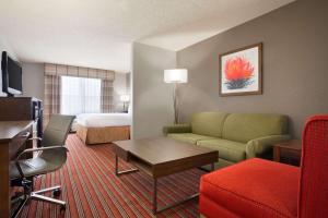 Habitación de hotel con sofá y cama en Country Inn & Suites by Radisson, DFW Airport South, TX, en Irving