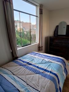 a bedroom with a bed and a large window at Departamento 3 niveles- Vista Panoramica 360 grados a toda la ciudad y Lago Titicaca in Puno
