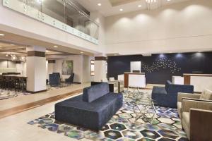 a lobby with blue couches and chairs in a building at Radisson Hotel Dallas North-Addison in Addison