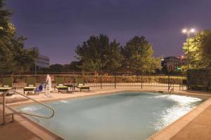a large swimming pool with chairs and a fence at Radisson Hotel Dallas North-Addison in Addison