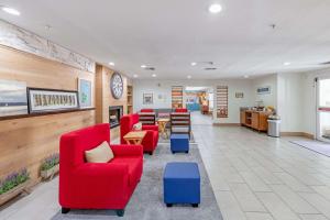 ルイスビルにあるCountry Inn & Suites by Radisson, Lewisville, TXの赤い椅子とテーブルが備わる待合室