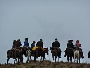 Hacienda Yanahurco في Ovejería: مجموعة من الناس يركبون الخيول في الميدان