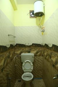 a bathroom with a toilet with a painting of a desert at Thulir in Vālpārai