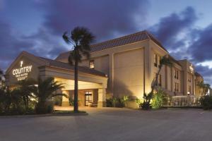 a building with a palm tree in front of it at Comfort Inn & Suites Portland - Corpus Christi in Portland