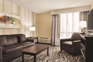 a living room with a couch and a table in a hotel room at Radisson Hotel Fort Worth North-Fossil Creek in Fort Worth
