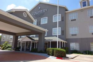 Country Inn & Suites by Radisson, Round Rock, TX في راوند روك: مبنى مع فندق مقاطعة usa