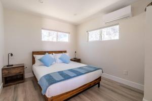 1 dormitorio con 1 cama y 2 ventanas en The Invisible Wind Cabin- Joshua Tree Amazing View, en Yucca Valley