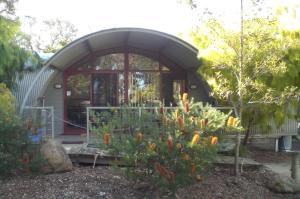 a small house with a garden in front of it at Mallacoota's Shady Gully Caravan Park in Mallacoota