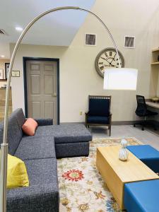 salon z kanapą i zegarem na ścianie w obiekcie Country Inn & Suites by Radisson, Fort Worth, TX w mieście Fort Worth