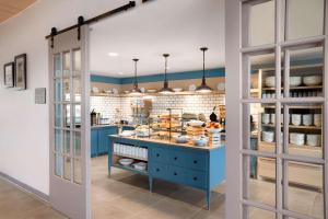 una cocina con una isla azul con comida. en Country Inn & Suites by Radisson, New Braunfels, TX en New Braunfels