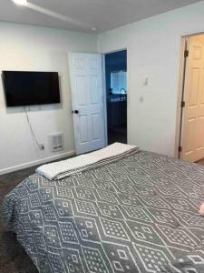 Schlafzimmer mit einem Bett und einem Flachbild-TV in der Unterkunft Hidden Gem in Downtown Tacoma in Tacoma