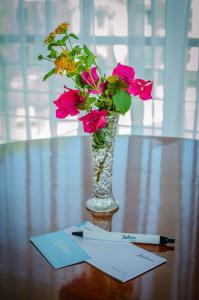 a vase of flowers on a table with a note at Radisson Hotel Colonia del Sacramento in Colonia del Sacramento