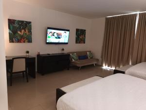 a hotel room with a bed and a tv on the wall at Playa Blanca Panama in Río Hato