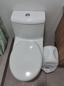 a white toilet in a bathroom with a trash can at Habitación Nueva Pareja o sola in Lima