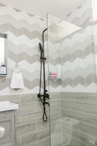 a shower with a glass door in a bathroom at EL Bonito II Juan Dolio DR 2 room sleeps6 1queen bed 2twin bed 1sofa bed in Juan Dolio