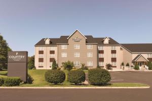 un hotel con un cartel frente a un edificio en Country Inn & Suites by Radisson, Roanoke, VA, en Roanoke