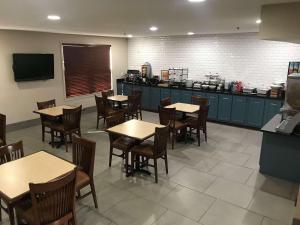 a dining room with tables and chairs and a kitchen at Country Inn & Suites by Radisson, Richmond I-95 South, VA in Richmond