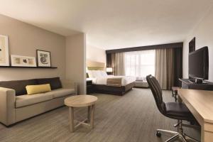 a hotel room with a couch and a bed at Country Inn & Suites by Radisson, Roanoke, VA in Roanoke