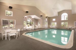 - une piscine dans une maison avec une table et des chaises dans l'établissement Country Inn & Suites by Radisson, Roanoke, VA, à Roanoke