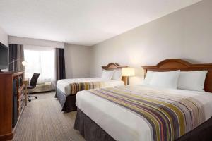 um quarto de hotel com duas camas e uma televisão em Country Inn & Suites by Radisson, Dahlgren-King George, VA em Dahlgren