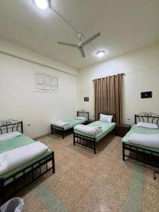 Zimmer mit 3 Betten und einem Deckenventilator in der Unterkunft Roman Theater Hotel in Amman