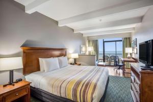 une chambre d'hôtel avec un lit et une télévision dans l'établissement Country Inn & Suites by Radisson, Virginia Beach Oceanfront , VA, à Virginia Beach
