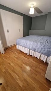 a bedroom with a bed and a wooden floor at Mysigt Stadsoas: En Modern lägenhet med 2 sovrum in Gothenburg