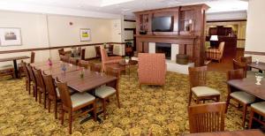 Un comedor con mesas y sillas y una chimenea. en Country Inn & Suites by Radisson, Fredericksburg, VA, en Fredericksburg