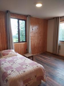 1 dormitorio con cama y ventana grande en Casa Cerro Divisadero, en Coyhaique