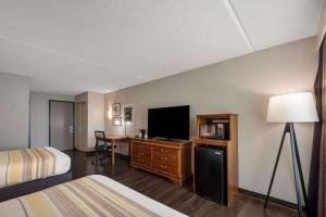 Cette chambre comprend un lit, un bureau et une télévision. dans l'établissement Country Inn & Suites by Radisson, Fredericksburg South I-95 , VA, à Fredericksburg