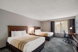 a hotel room with two beds and a desk at Country Inn & Suites by Radisson, Fredericksburg South I-95 , VA in Fredericksburg